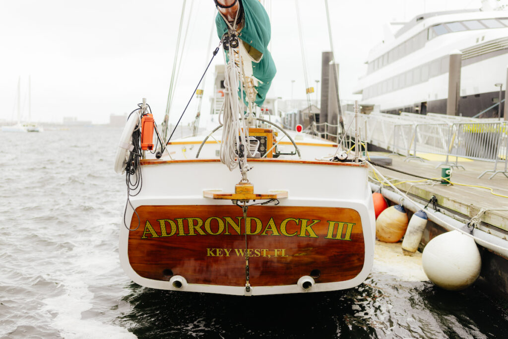 Back view of the Adirondack III sailboat docked at Boston Harbor, ready for sailing adventures with classic harbor line.