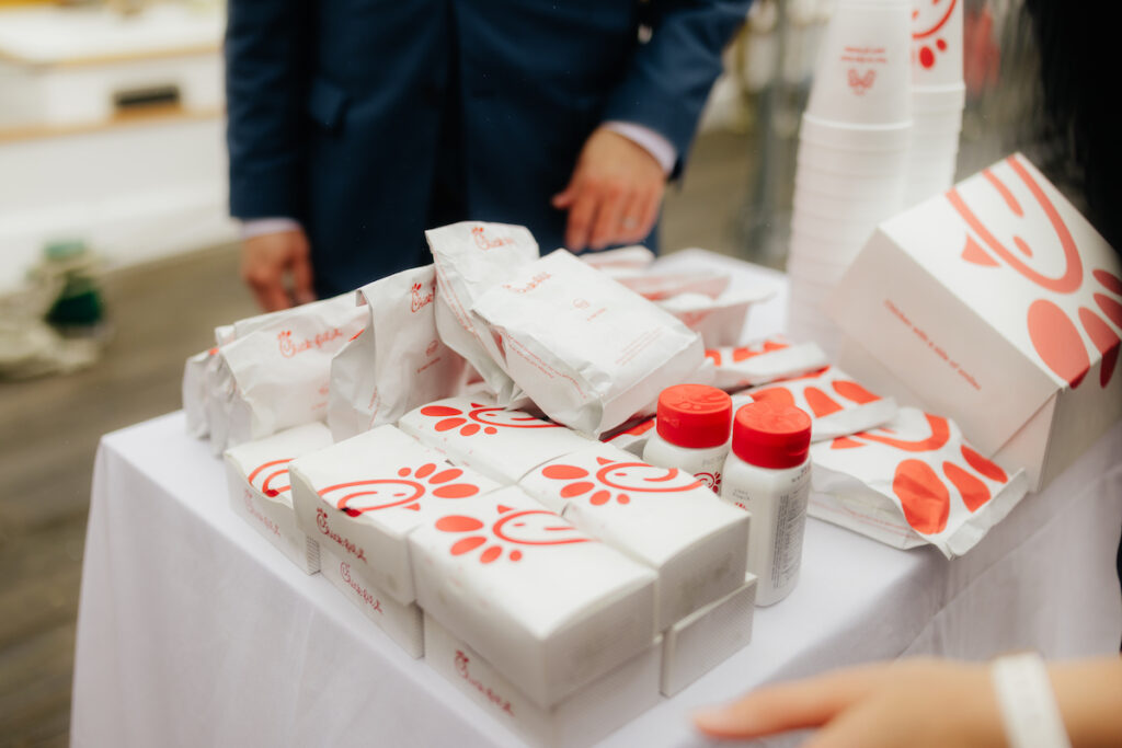 Fast food items and sauces on a table, customer in background.